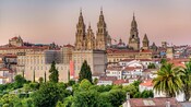 Una catedral Gótica ornamentada con 3 campanarios que destacan en una ciudad europea